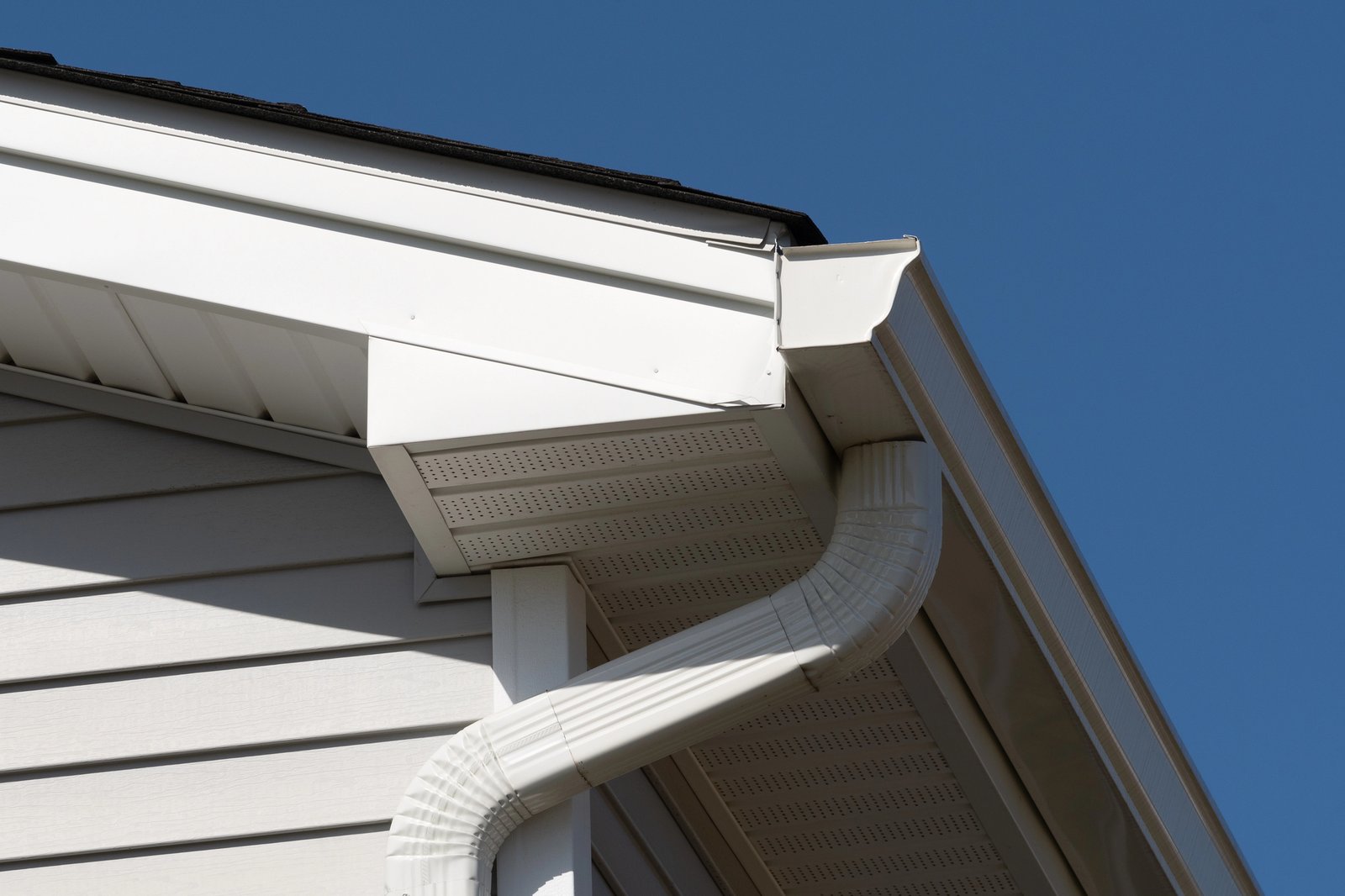 Seamless white aluminum gutters and downspout on a residential home